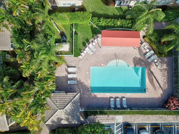 an aerial view of a house with a yard and a lot of flower plants