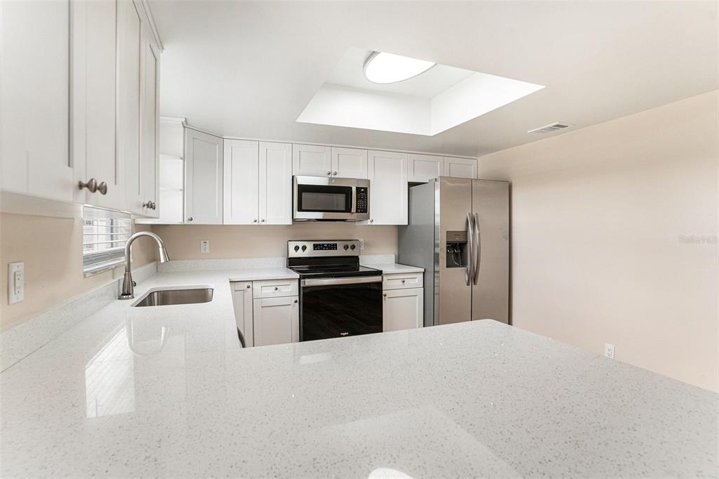 2527 Ridge Top Way Valrico, FL 33594 - Photo 9 of 29 a kitchen with granite countertop a refrigerator a sink a stove a microwave and wooden cabinets