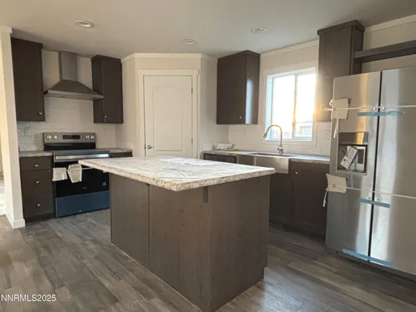 a kitchen with stainless steel appliances granite countertop a refrigerator a stove a sink and a microwave