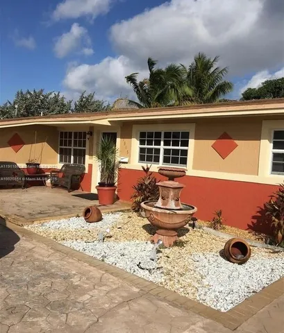 a view of a house with backyard porch and sitting area