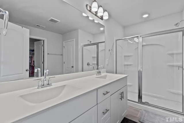 a spacious bathroom with a double vanity sink toilet and a mirror