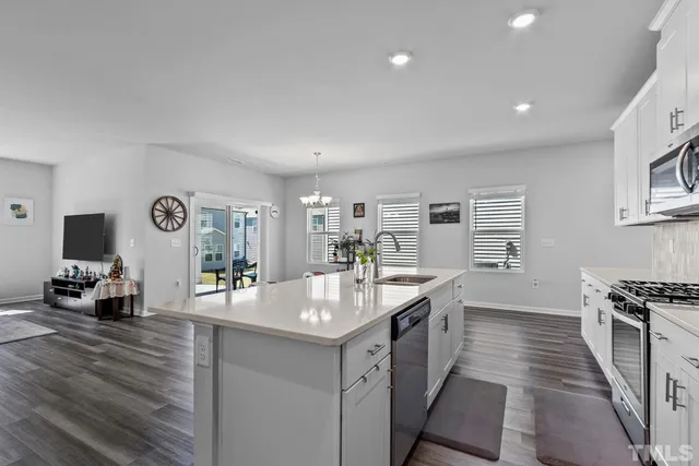 a kitchen with stainless steel appliances granite countertop a refrigerator microwave and wooden floors