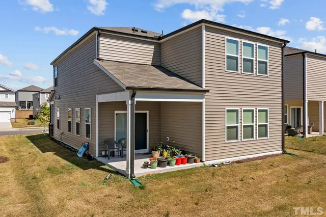 a view of a house with potted plants and a large window