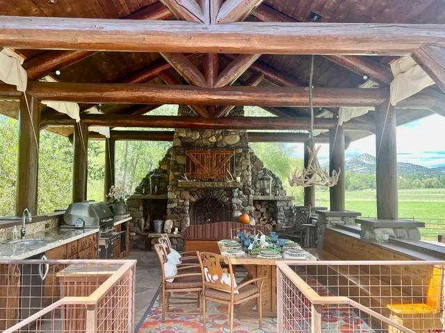 a view of a patio with table and chairs potted plants with wooden floor and fence
