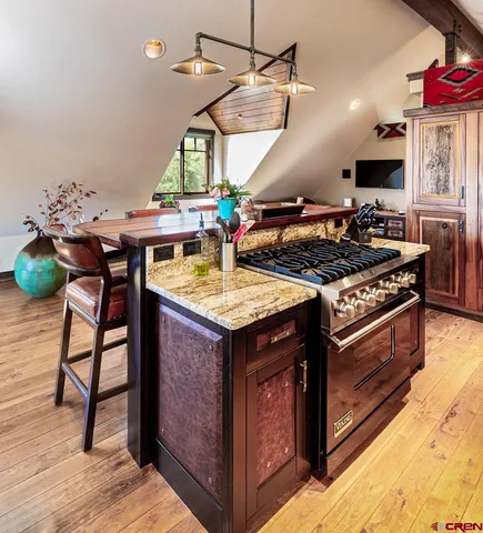 a kitchen with stainless steel appliances granite countertop a stove a sink and a microwave