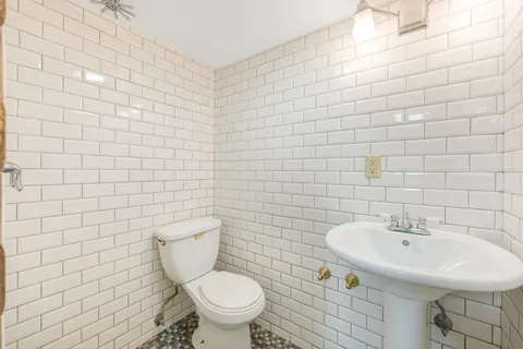 a bathroom with a sink a toilet and a mirror