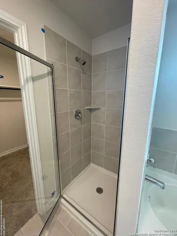 a bathroom with a shower and a glass door