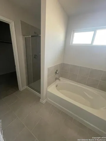 a spacious bathroom with a bathtub and shower