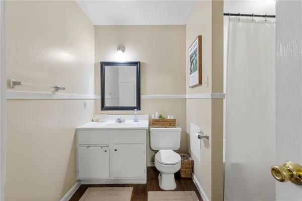 a bathroom with a toilet sink vanity and mirror