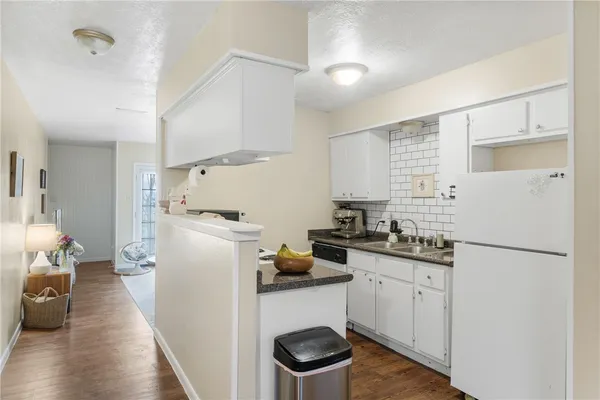 a kitchen with a sink a refrigerator and cabinets