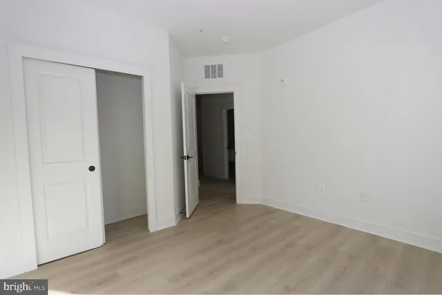 an empty room with closet and mirror