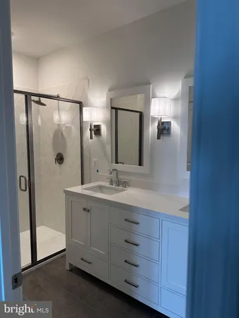 a bathroom with a granite countertop sink mirror and shower