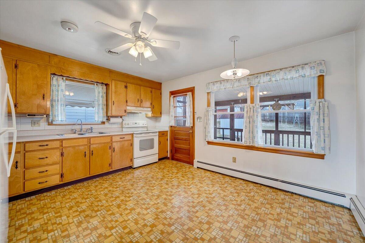 626 Santee Road Roanoke, VA 24019 - Photo 8 of 56 a large white kitchen with granite countertop a stove a sink dishwasher and a refrigerator with wooden floor