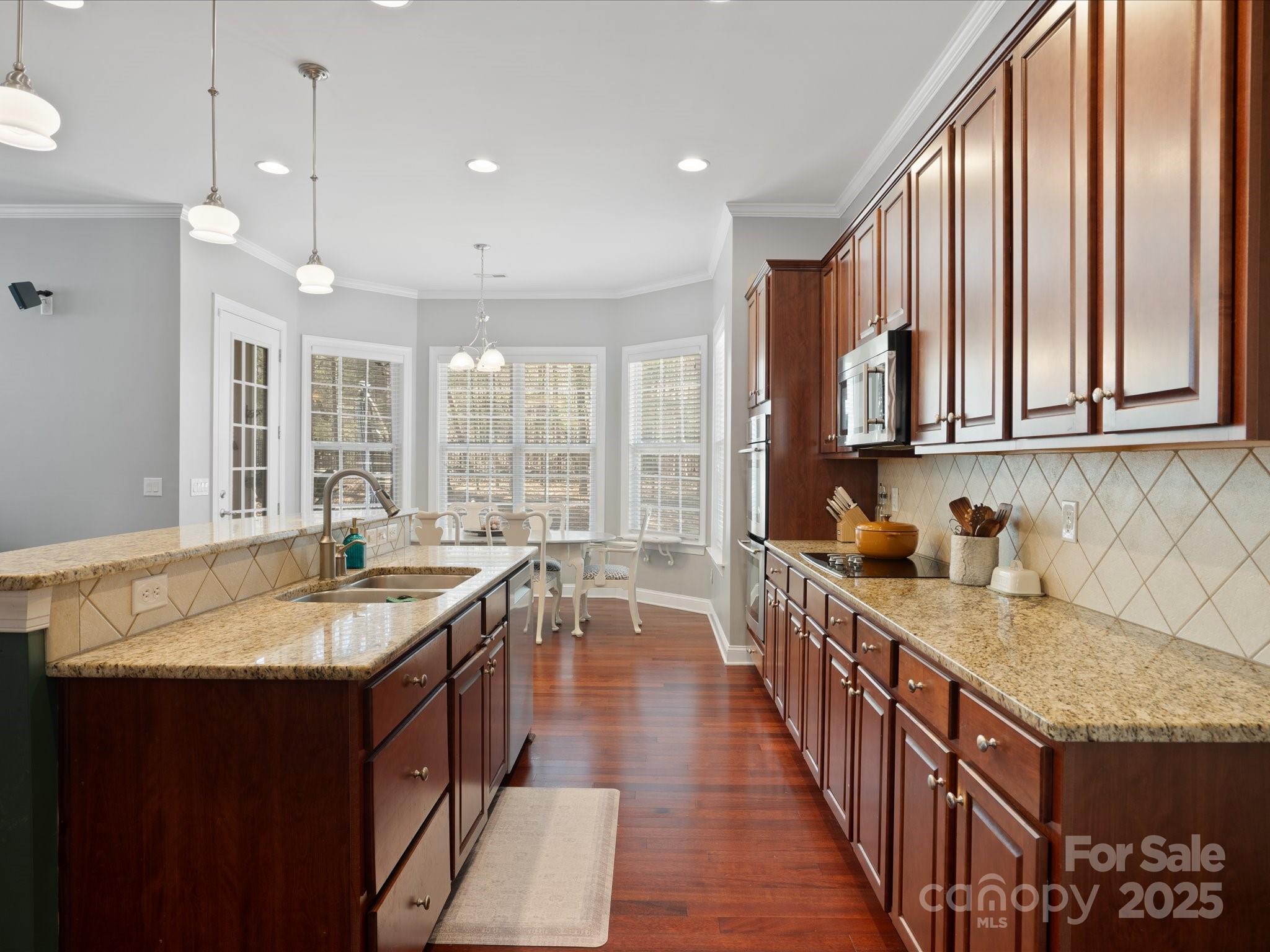 567 Quicksilver Trail Fort Mill, SC 29708 - Photo 12 of 37 a kitchen with kitchen island granite countertop a sink stove and cabinets