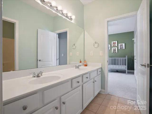 a en suite bathroom with a double vanity sink and a mirror
