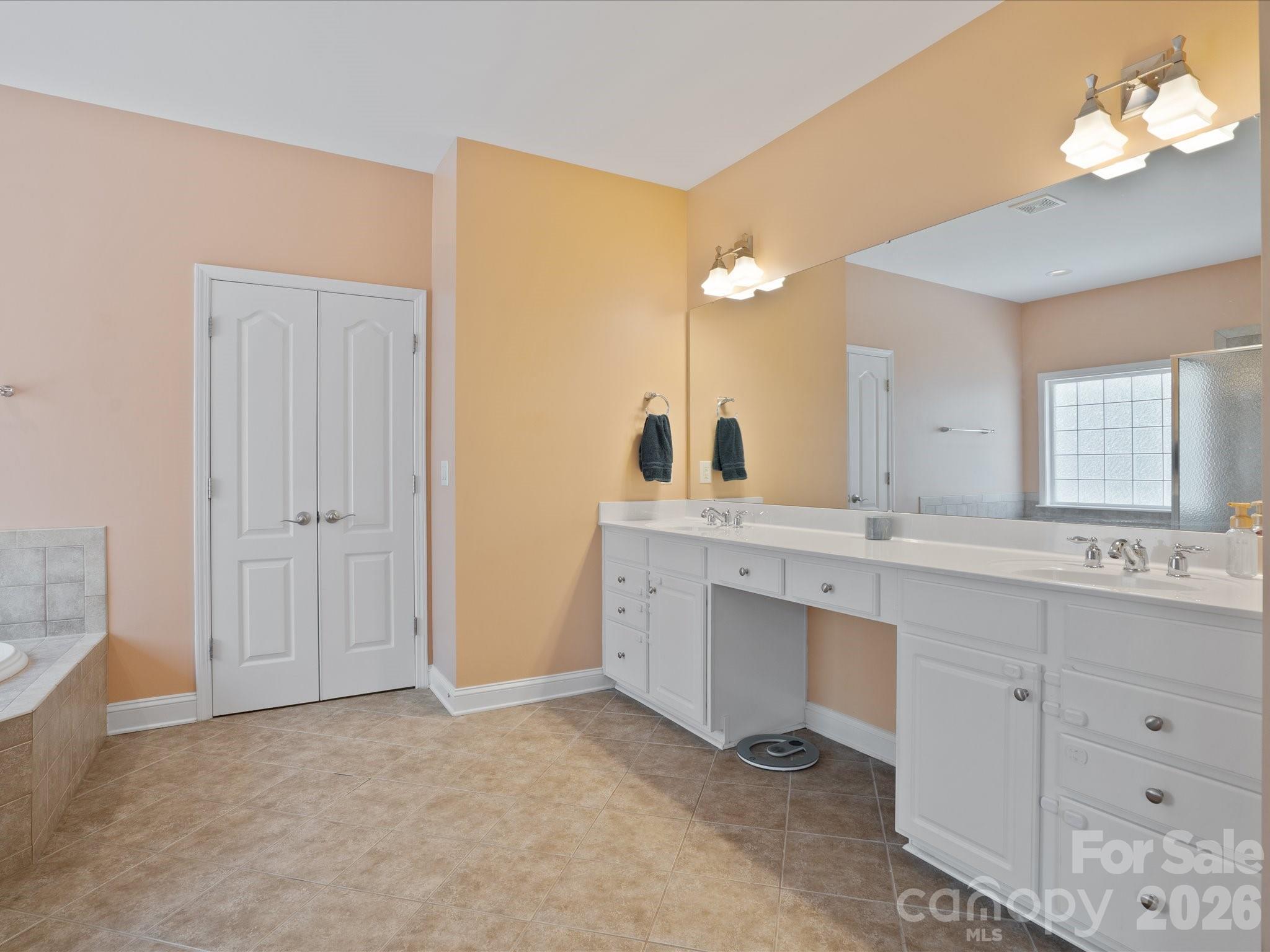 567 Quicksilver Trail Fort Mill, SC 29708 - Photo 25 of 37 a bathroom with a double vanity sink a mirror and a bathtub
