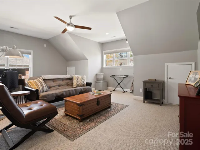 a living room with furniture a ceiling fan and a rug