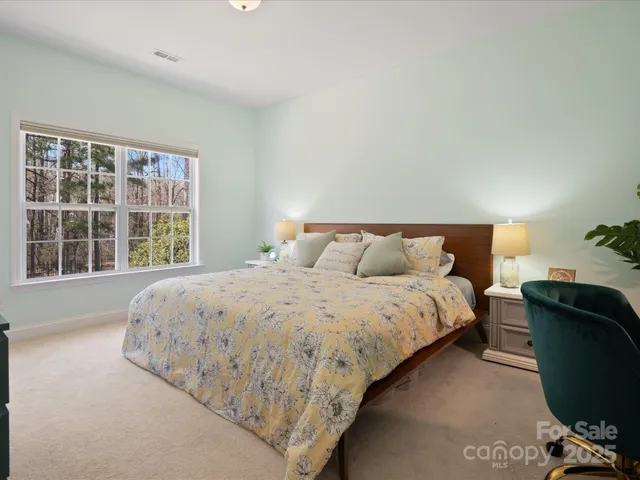 a bed sitting in a bedroom next to a window