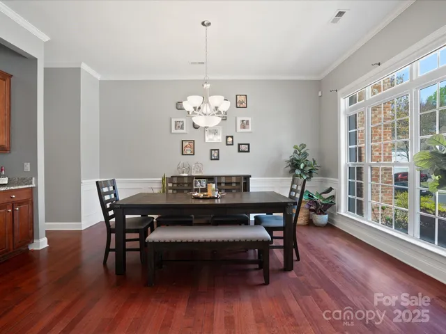 a view of a dining room with furniture wooden floor and chandelier
