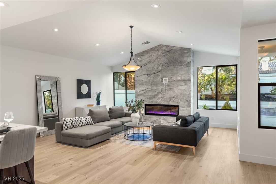 2316 Prometheus Court Henderson, NV 89074 - Photo 22 of 92 Living room with light wood-style floors, a fireplace, lofted ceiling, and plenty of natural light