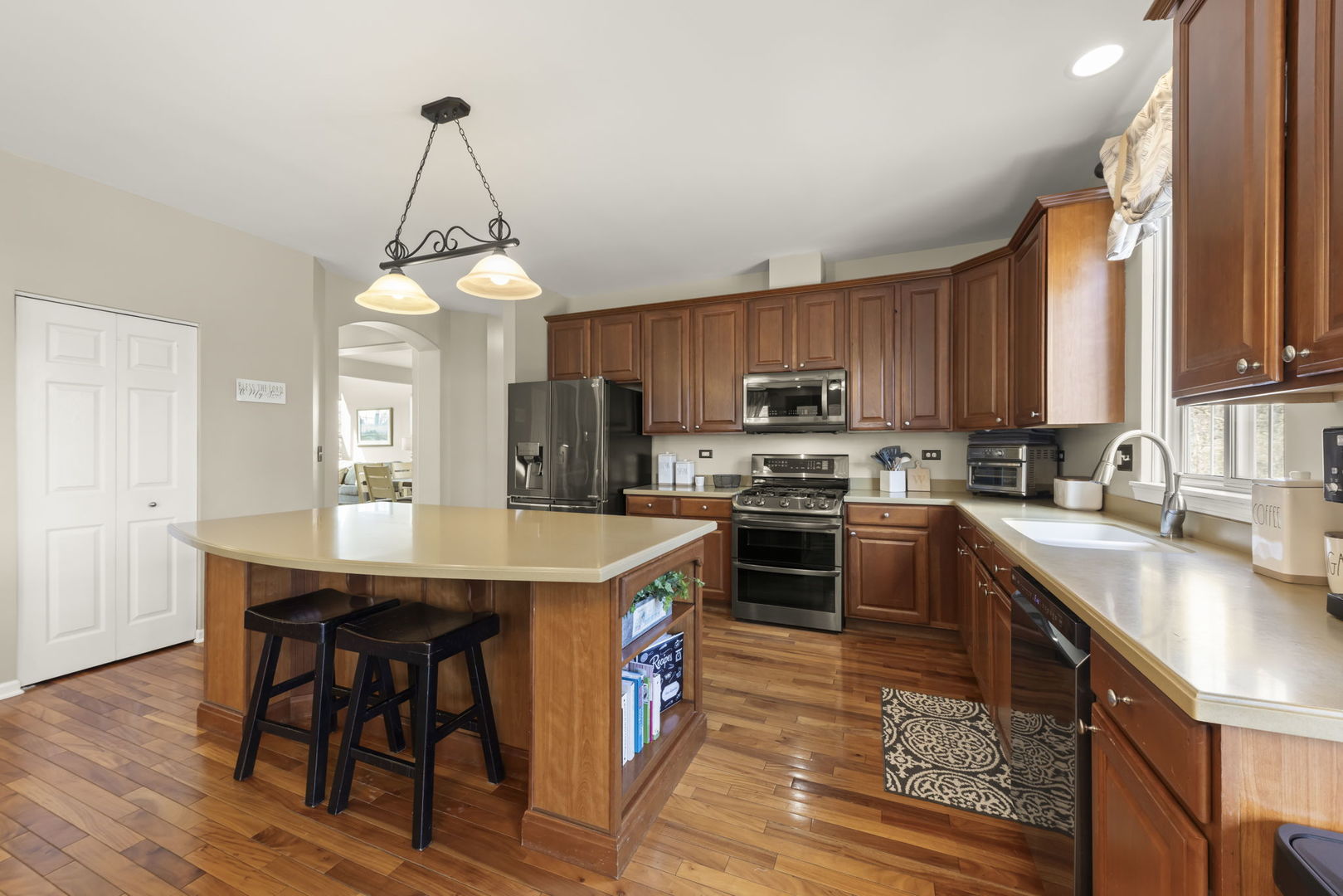 1934 Raintree Road Yorkville, IL 60560 - Photo 7 of 40 a kitchen with stainless steel appliances granite countertop a stove top oven a sink dishwasher a dining table and chairs with wooden floor