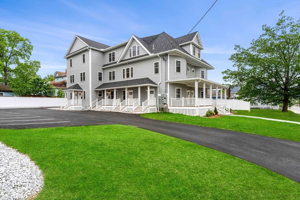 1280 Middlesex Street Lowell, MA 01851 - Photo 3 of 35 a front view of a house with a garden and trees