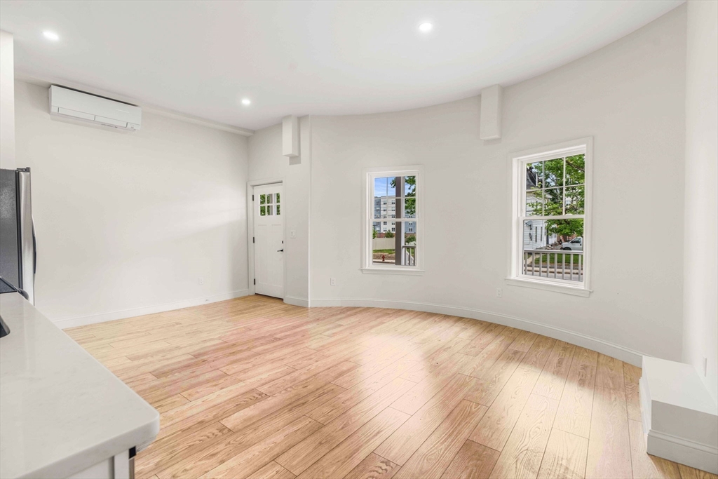 1280 Middlesex Street Lowell, MA 01851 - Photo 7 of 35 a view of an empty room with wooden floor and a window