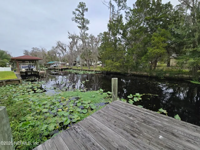 a backyard of a house with lots of green space and lake view