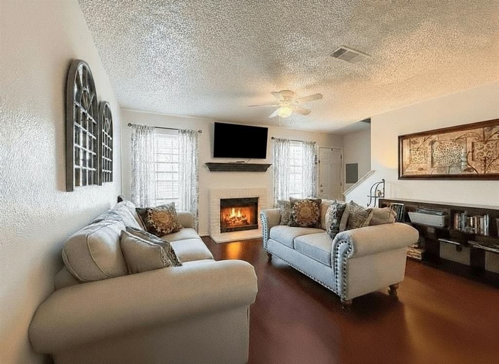 1237 Dallas Drive Denton, TX 76205 - Photo 2 of 18 a living room with furniture a flat screen tv and a fireplace