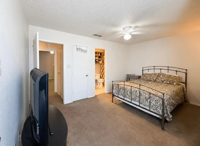 a bedroom with a bed and a flat tv screen on a table