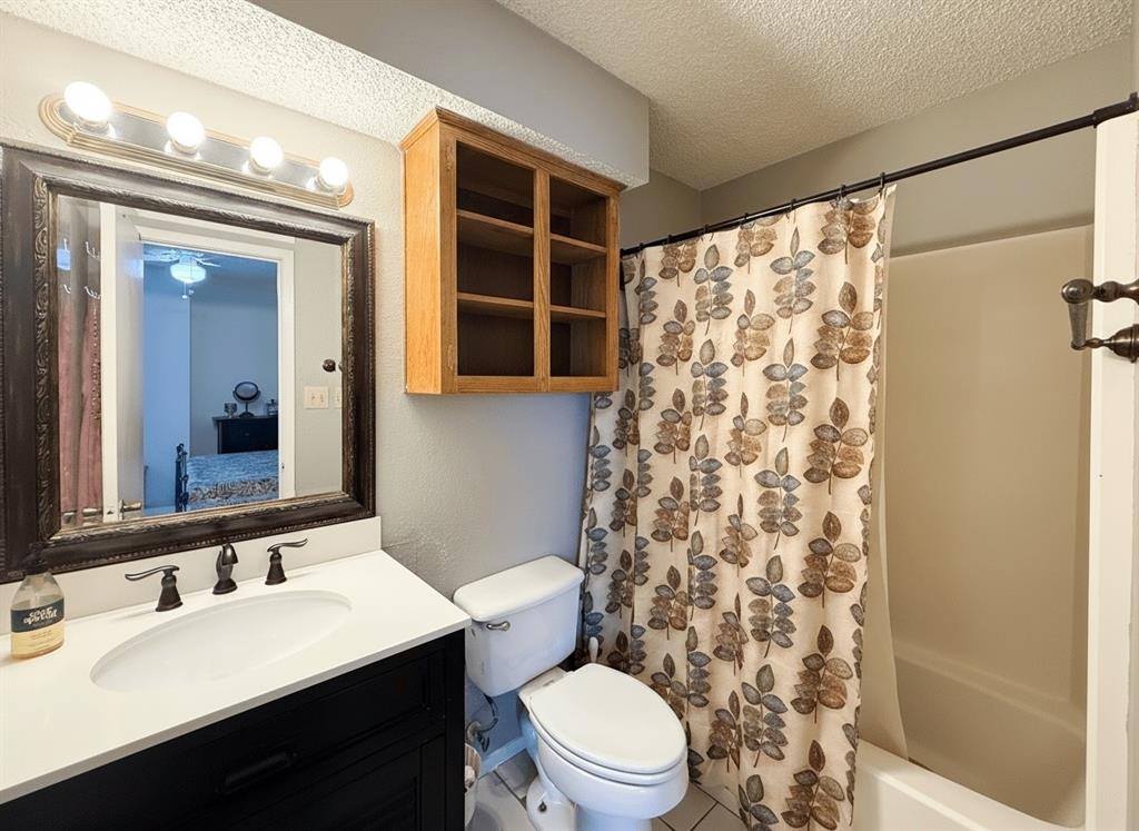 1237 Dallas Drive Denton, TX 76205 - Photo 9 of 18 a bathroom with a sink a toilet a mirror and shower