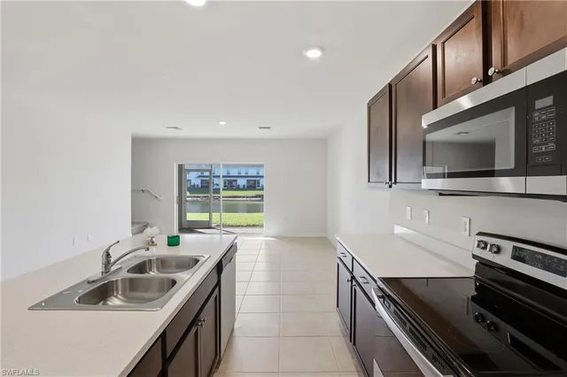 a kitchen with a sink and a stove top oven with wooden floor