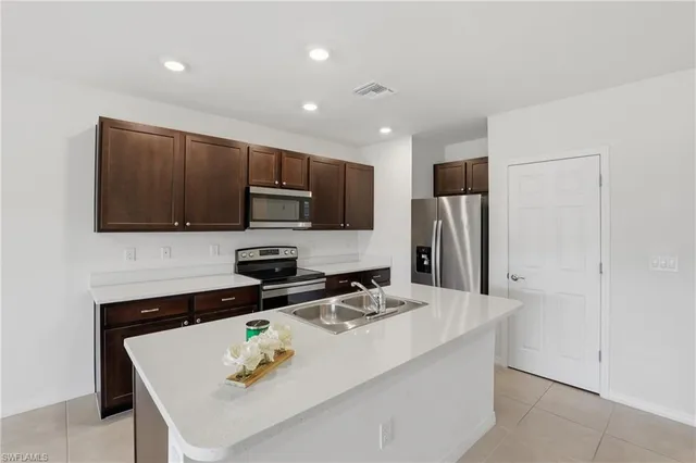 a kitchen with stainless steel appliances a microwave a sink and a refrigerator