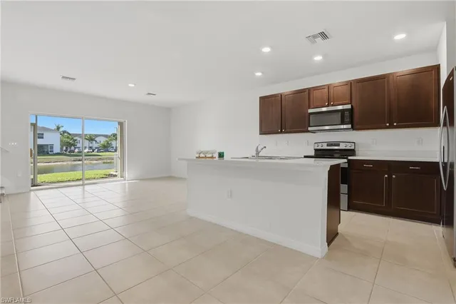 a kitchen with stainless steel appliances a stove a sink a microwave a counter top and cabinets