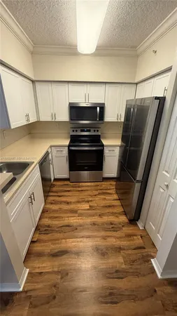 a view of kitchen with stove and refrigerator
