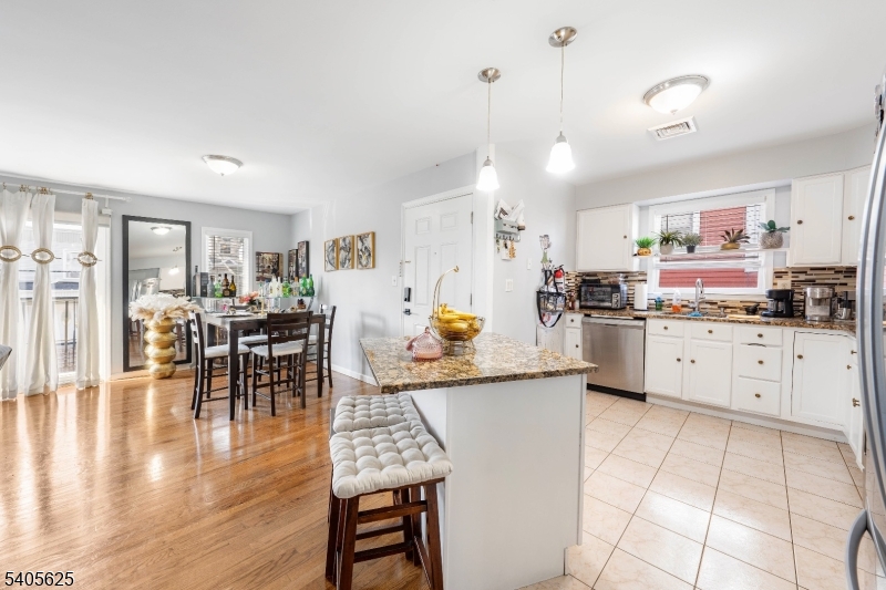 118 Race Street, Unit 2 Elizabeth, NJ 07202 - Photo 2 of 16 a kitchen with stainless steel appliances kitchen island granite countertop a table chairs and a refrigerator