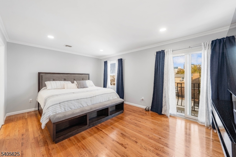 118 Race Street, Unit 2 Elizabeth, NJ 07202 - Photo 9 of 16 a bedroom with a bed and wooden floor