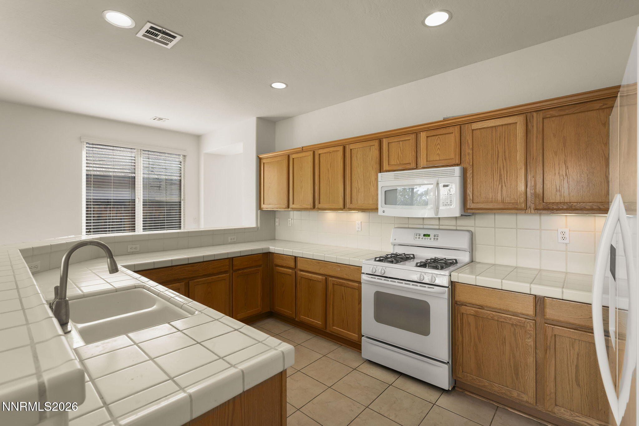 1710 Autumn Valley Way Reno, NV 89523 - Photo 13 of 25 a kitchen with granite countertop a stove sink and cabinets