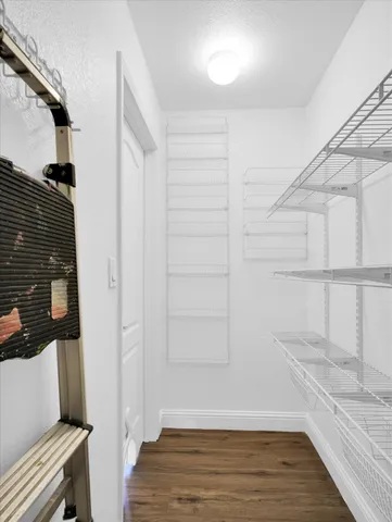 a view of a room with wooden floor and door