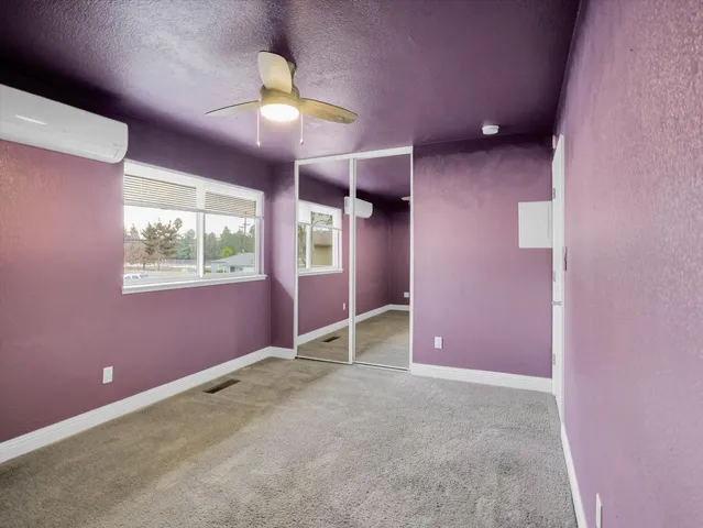 a view of a big room with windows and chandelier fan