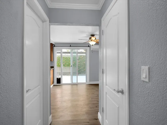 a view of an empty room with wooden floor and a window