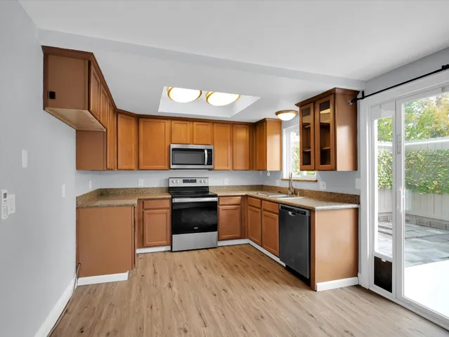 a large kitchen with stainless steel appliances granite countertop a stove and a sink