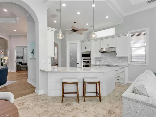 a large kitchen with kitchen island a island a sink stainless steel appliances and cabinets