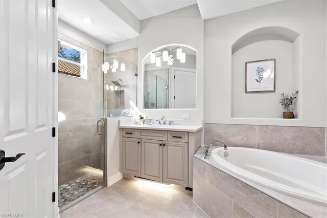 a bathroom with a tub a double vanity sink and a mirror