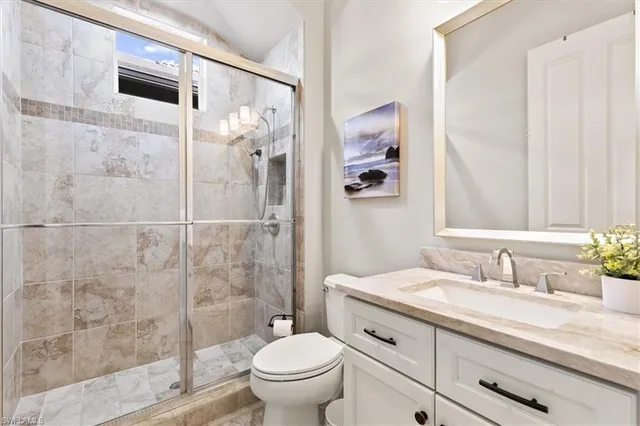 a bathroom with a granite countertop sink toilet and shower