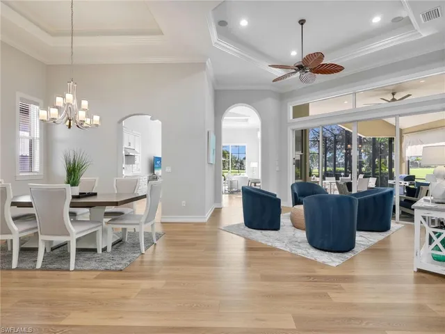 a dining room with furniture a chandelier and a window