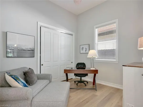 a spacious bedroom with a bed a couch and a large window