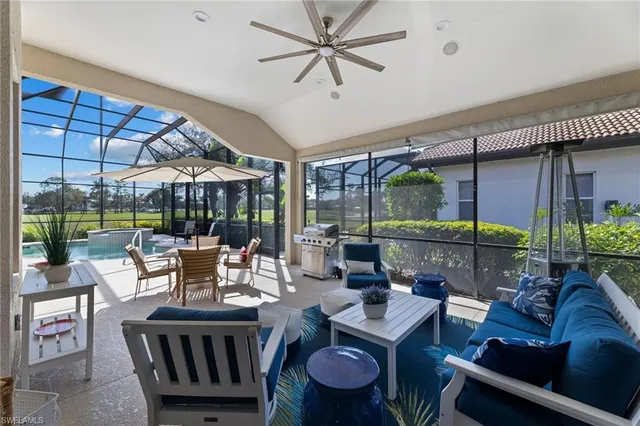 a living room with patio furniture and a floor to ceiling window