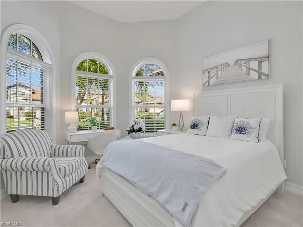 a bedroom with a large bed and a chandelier