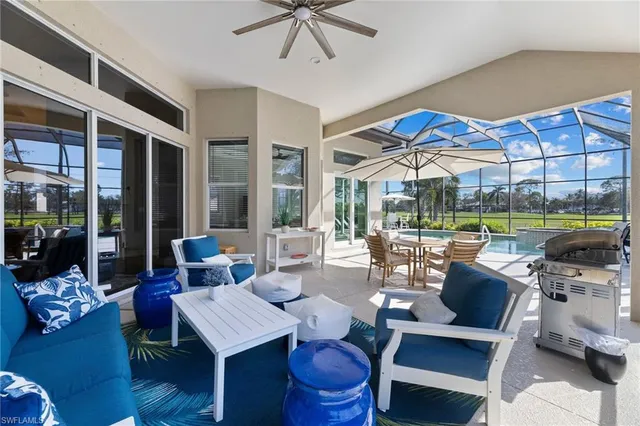 a living room with patio furniture and a floor to ceiling window